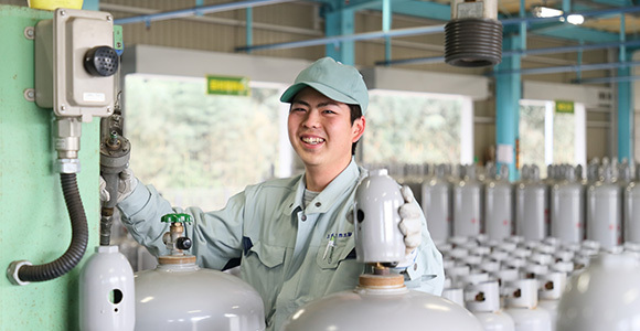 写真:ガスボンベにLPガスの充填をする社員