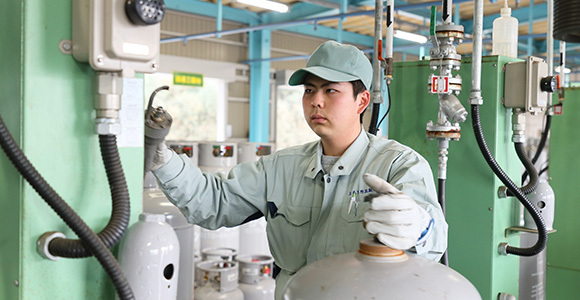 写真:ガスボンベにLPガスの充填をする社員