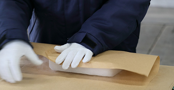 写真:ドライアイスを梱包する作業員の手元