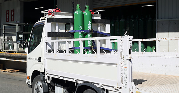 写真:トラックに荷台にガスボンベが固定されている